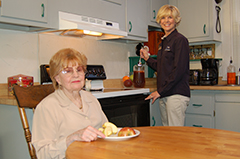 Caregiver and woman in kitchen