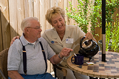 Caregiver pouring tea for senior
