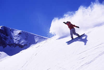 Snowboarder enjoying the sun on the slopes.